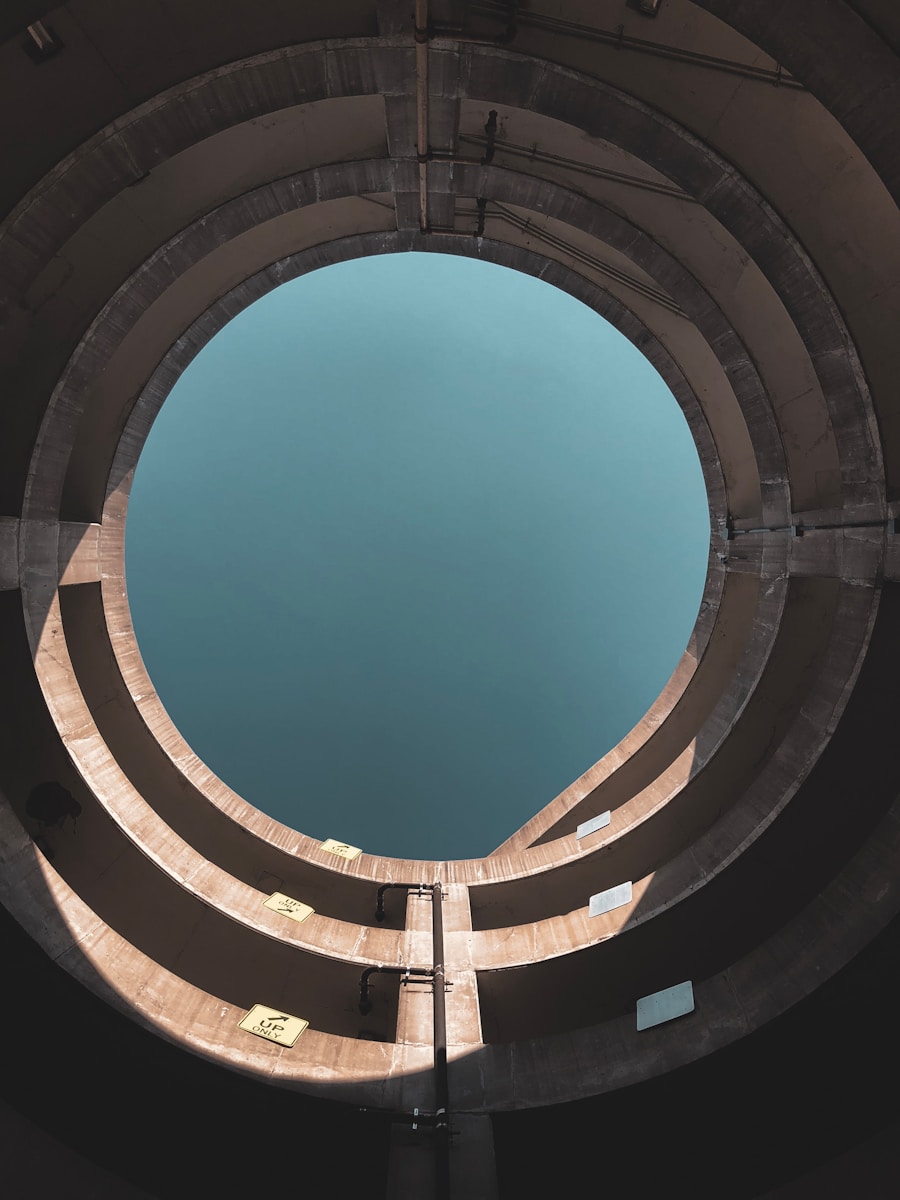 looking up at a circular concrete structure with a blue sky in the background